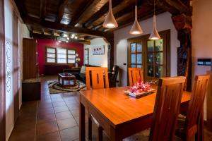 uma cozinha e sala de jantar com uma mesa de madeira e cadeiras em CASA RURAL BAKUBITXI em Murguía