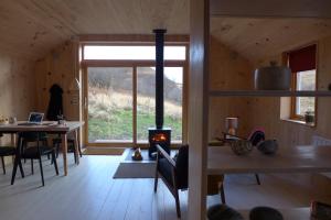 una sala de estar con chimenea en una casa de madera en The Tin Church, en Port na Long
