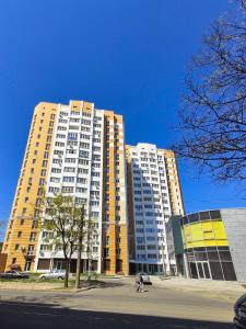 ein großes gelbes und weißes Apartmenthaus auf einer Straße in der Unterkunft Apartment near stadio Metalist Kharkiv in Kharkov