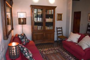 - un salon avec deux canapés rouges et une bibliothèque dans l'établissement Il Carmine Charme & Terrace with AC, à Lucques