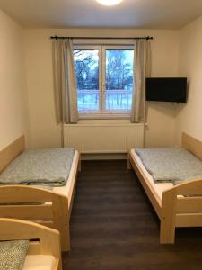 2 camas en una habitación con ventana en Penzion Alvarez en Ostrov nad Oslavou