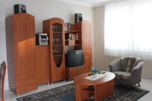 a living room with a tv and wooden furniture at Pine Wood Apartment 6 in Zalakaros
