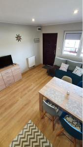 a living room with a table and a couch at Apartamenty Ster Darłówko in Darlowko