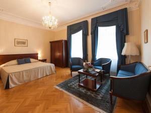 a bedroom with a bed and chairs and a table at Hotel Ambassador in Vienna