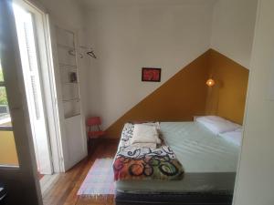 Dormitorio pequeño con cama con cabecero de madera en Hospedaria - A Casa Café Arte - Valores Acessíveis, en São Paulo