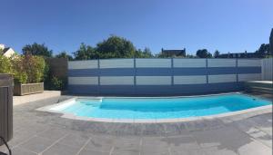 a swimming pool in a backyard with a fence at Villa Métisse Ile et Villas Groix in Groix
