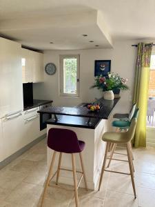 een keuken met 2 barkrukken en een aanrecht bij Résidence Coté Village in Valbonne