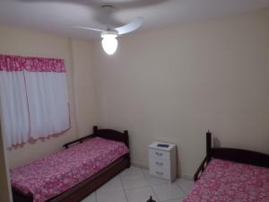 um quarto com 2 camas e uma ventoinha de tecto em Aconchego no Paraíso em Arraial do Cabo