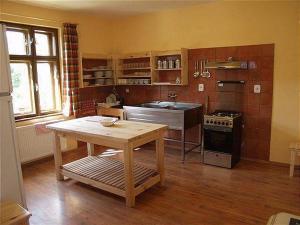 a kitchen with a table and a sink and a stove at Chalet Horáren in Smižany
