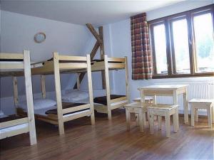 Cette chambre comprend 2 lits superposés et une table. dans l'établissement Chalet Horáren, à Smižany