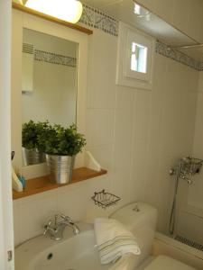 a bathroom with a sink and a toilet and a mirror at Chez Semiramis The Sun Touch House for 8 persons 5'min from the beach in Rámos