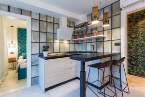 een keuken met een zwart aanrecht en krukken bij Villa Capitis in the Centre Two units- Private Pool Villa & Balcony Apartment with No Pool in Hvar
