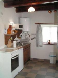 a kitchen with a white stove top oven next to a window at Holiday home- Galóca in Helesfa