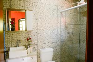 a bathroom with a toilet and a sink and a mirror at Chalé vista da mata in Visconde De Maua +18 photos