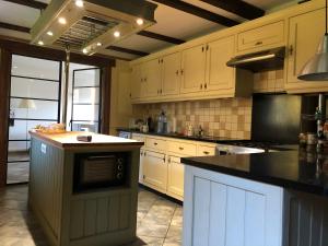 a kitchen with white cabinets and a black counter top at Leśna Willa in Kowalewo