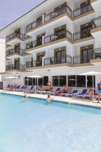 a hotel with a swimming pool in front of a building at Guya Wave Hotel in Cala Ratjada