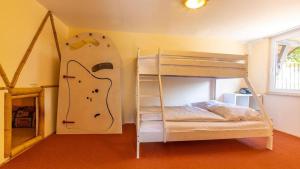 ein Schlafzimmer mit einem Etagenbett und einem Surfbrett an der Wand in der Unterkunft Hexenhaus kleine Finka in Prerow