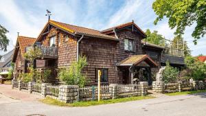 ein Holzhaus mit einem Zaun davor in der Unterkunft Hexenhaus kleine Finka in Prerow