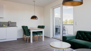 - un salon avec une table et un canapé vert dans l'établissement Apartmenthaus Wittsande Wittsande 11, à Zingst