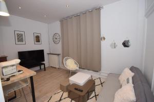 uma sala de estar com um sofá e uma televisão em CHIC APPART DESIGN - HYPER CENTRE - TRAMWAY - FREE WIFI - leRelaisdOdile12 em Valenciennes