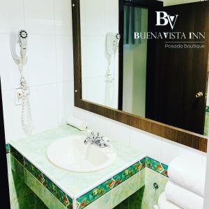 a bathroom with a sink and a mirror at BUENAVISTA INN in Maiquetía
