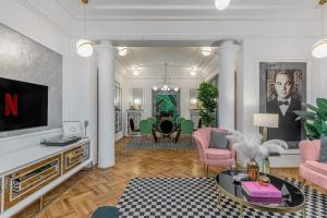 uma sala de estar com mobiliário rosa e uma televisão em HOLT - The Great Gatsby em Bucareste