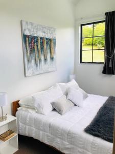 a bed with white sheets and pillows in a bedroom at Spacious, Peaceful, Fully Equipped 1BR Apartment in Upper Hutt