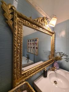 een badkamer met een grote gouden spiegel boven een wastafel bij Marabeth Guest House in Zagreb