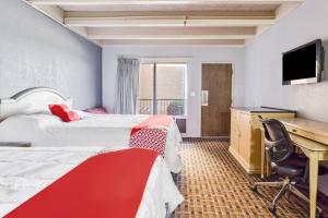 a hotel room with two beds and a desk at OXFORD INN, Lincoln Blvd in Oklahoma City