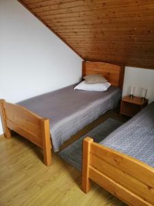 two twin beds in a room with wooden ceilings at Kolpinghaus in Caransebeş