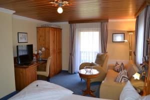a hotel room with a bed and a living room at Hotel Alpenresi in Ramsau
