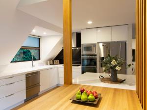 a kitchen with white cabinets and a plate of fruit at Mountain Utopia in Queenstown
