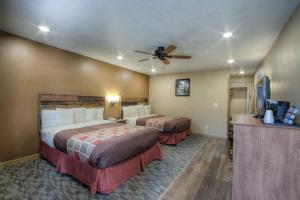 a hotel room with a bed, desk and a television at Powder House Lodge in Keystone