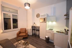 a small kitchen and a living room with a table and chairs at CONFORT APPART - HYPERCENTRE - TRAMWAY - leRelaisdOdile14 in Valenciennes