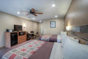um quarto de hotel com uma cama e uma televisão de ecrã plano em Powder House Lodge em Keystone