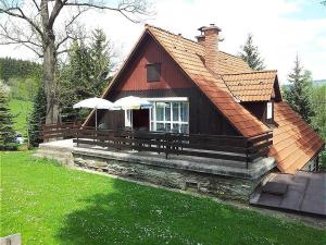 een klein huis met twee parasols op de veranda bij Villa- Roubenka in Víchová nad Jizerou