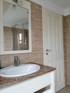 un baño con lavabo y espejo en Kolpinghaus, en Caransebeş