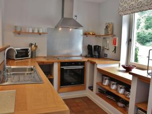 una cucina con lavandino e piano cottura forno superiore di Spacious Holiday Home in Rendeux with Sauna a Rendeux