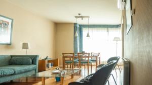 sala de estar con sofá, mesa y sillas en Mitre Independent en Mendoza