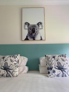 a picture of a koala hanging above a bed at Botanic City Apartments in Warrnambool