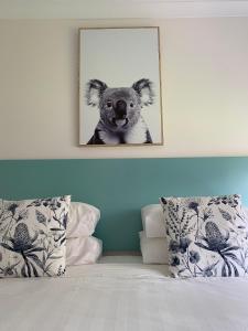 a picture of a koala hanging above a bed at Botanic Apartments in Warrnambool