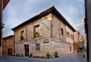 an old brick building with potted plants on the windows at Areta Etxea in Salinillas de Buradón