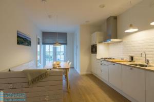 a kitchen with white cabinets and a sink at Appartement - Kaapduinseweg 13 Dishoek 13A Luxe 4 personen in Dishoek
