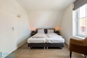 a bedroom with a bed in the corner of a room at Appartement - Kaapduinseweg 13 Dishoek 13D Luxe 6 personen in Dishoek