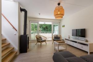 a living room with a couch and a tv at Appartement - Kaapduinseweg 13 Dishoek 13-k Luxe 6 personen in Dishoek