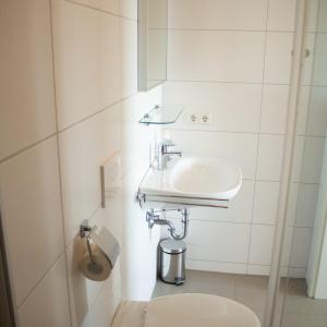 uma casa de banho branca com um lavatório e um WC em Appartement Resort Winterberg - Neuastenbergerstrasse 39-41 em Winterberg