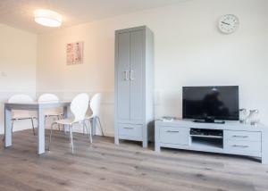 een woonkamer met een televisie en een tafel en stoelen bij Ferienwohnung - Am Roten Kreuz 11 in Winterberg