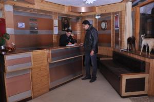 two men standing at a counter in a bar at Hotel Prestige in Shimla