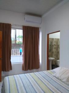 sypialnia z łóżkiem, oknem i umywalką w obiekcie apartamento 3 w mieście Fortuna