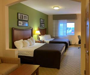 a hotel room with two beds and a couch at Sleep Inn & Suites Gettysburg in Gettysburg